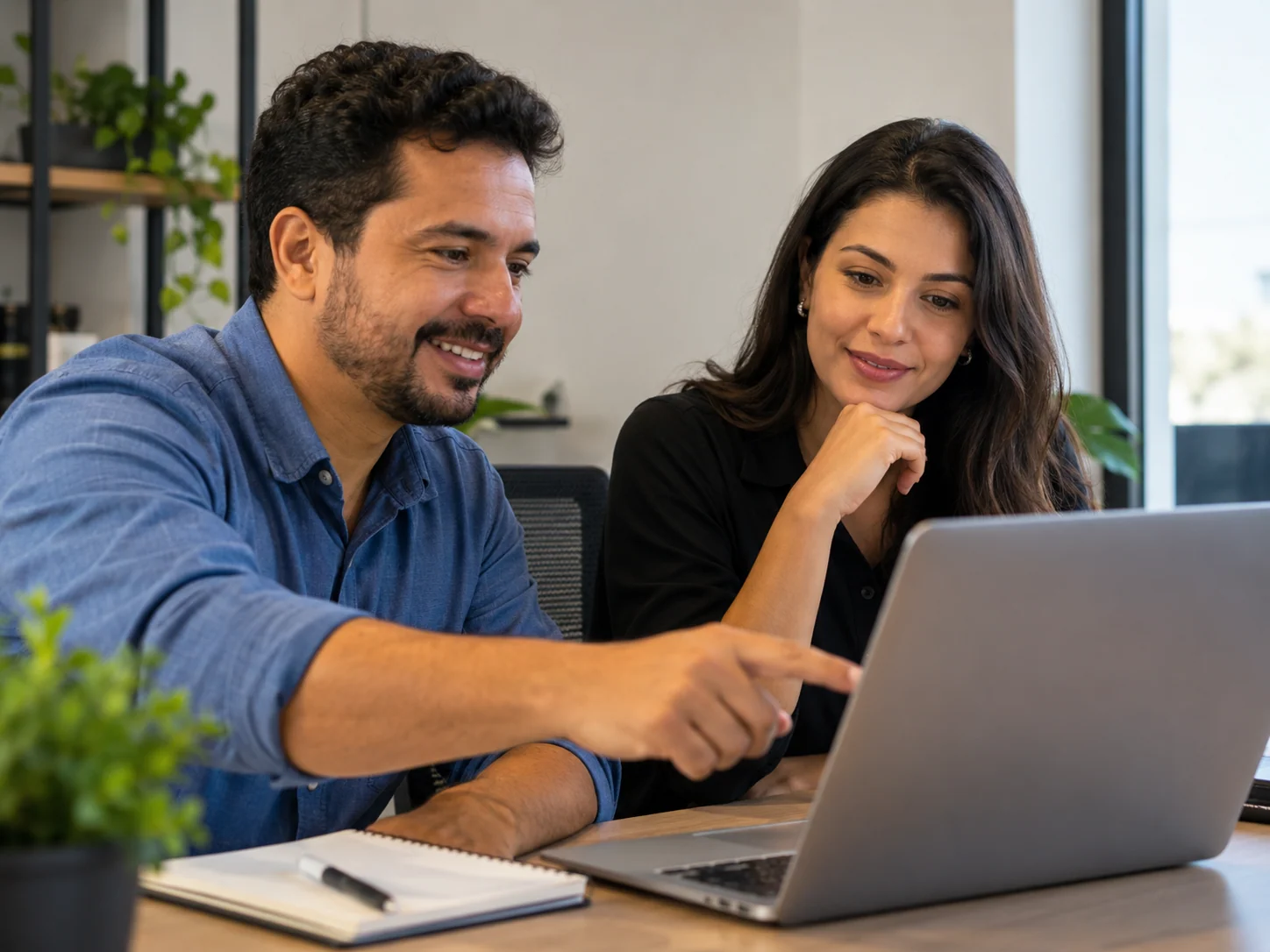 Duas pessoas conversando em torno de um notebook